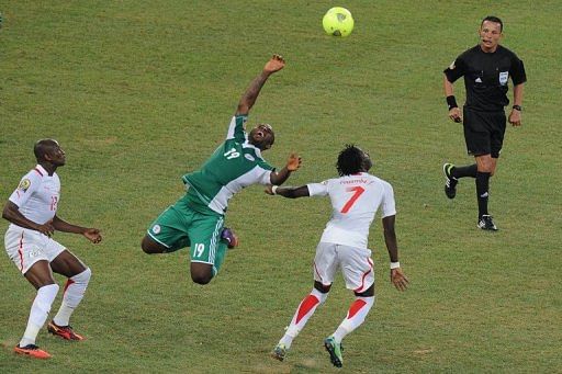 Nigerian forward Sunday Mba (centre) fights for the ball with Burkina Faso's midfielder Florent Rouamba (second right)